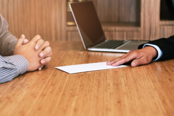 Funcionário deixando escritório carregando caixa de pertences pessoais, expressão séria, corredor corporativo, fotografia realista sobre rescisão indireta